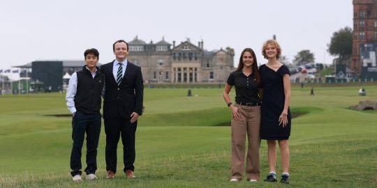 The four scholars stand smiling together on the edge of the Old Course, with the Royal & Ancient clubhouse behind them The four scholars stand smiling together on the edge of the Old Course, with the Royal & Ancient clubhouse behind them
