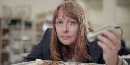 Sabine Hyland studying a khipu with a hand-held microscope. Sabine Hyland studying a khipu with a hand-held microscope.