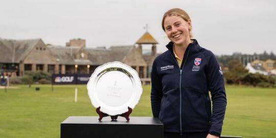 Ellie Monk stands smiling on the Old Course wearing Saints Golf kit, she poses next to the individual stroke play salver Ellie Monk stands smiling on the Old Course wearing Saints Golf kit, she poses next to the individual stroke play salver