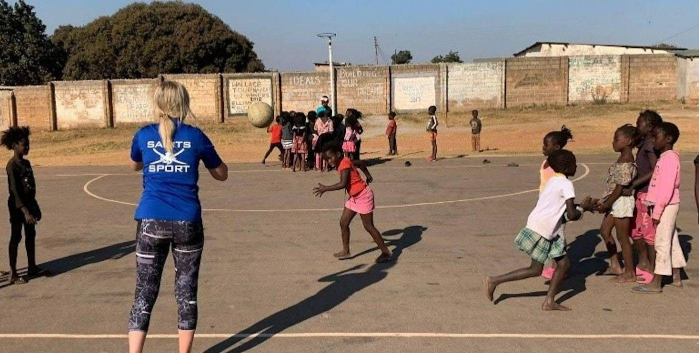 A student volunteer playing sport with children in Zambia