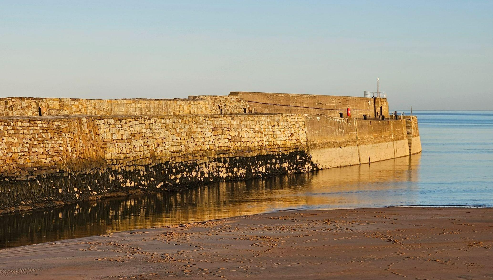 A historic pier, sea and beach at sunset A historic pier, sea and beach at sunset