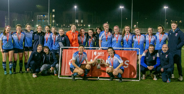 The women's football team holding a trophy The women's football team holding a trophy