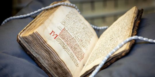 St Andrews Chronicles sits cushioned on display, the pages open to reveal the historic writing.