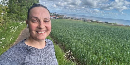 Clarissa Melo Czeskter poses for a selfie on a run on Grange Road, greenery can be seen in the background
