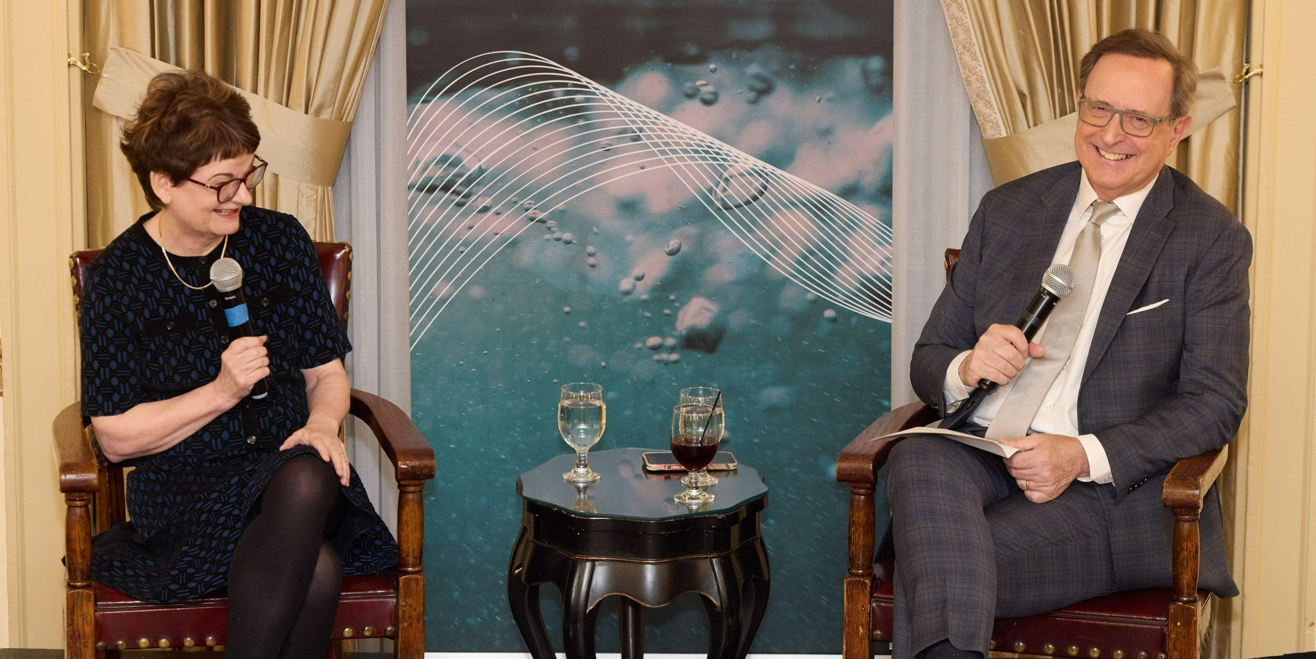 Two people are seated, smiling, and holding microphones. They are participating in an 'in conversation with' style event to an audience. On the left is the Principal of the University of St Andrews, Professor Dame Sally Mapstone, and on the right is Special Correspondent for the news channel CBS, Anthony Mason. Two people are seated, smiling, and holding microphones. They are participating in an 'in conversation with' style event to an audience. On the left is the Principal of the University of St Andrews, Professor Dame Sally Mapstone, and on the right is Special Correspondent for the news channel CBS, Anthony Mason.
