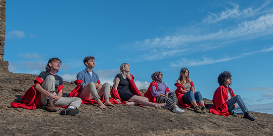 students sitting on a rock