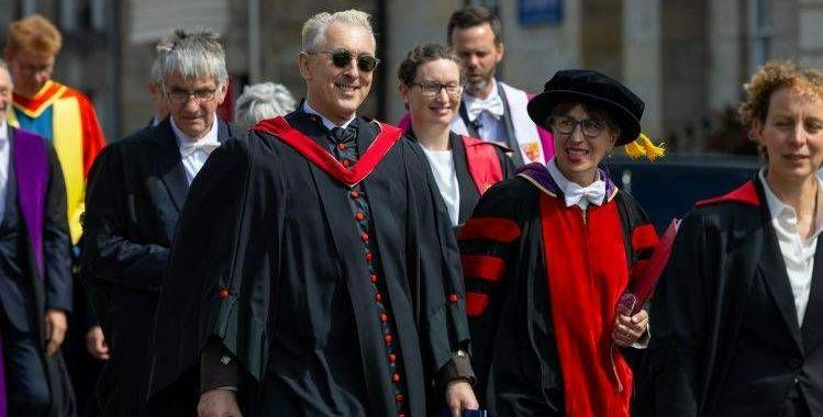 The actor Alan Cumming, pictured in graduation robes and sunglasses, participating in the graduation procession at the University of St Andrews The actor Alan Cumming, pictured in graduation robes and sunglasses, participating in the graduation procession at the University of St Andrews