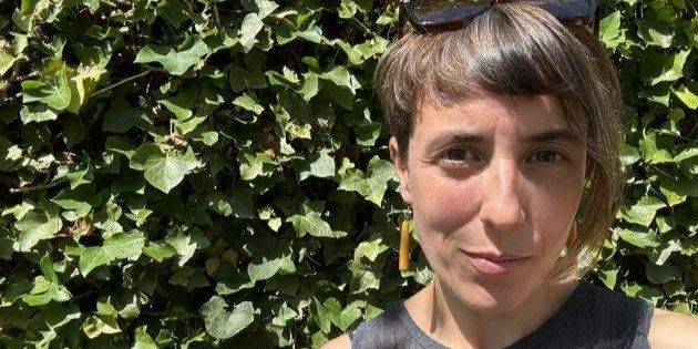 The image shows Dr Kristen Treen, a lecturer in the School of English at the University of St Andrews, in the sunshine in front of a green, leafy plant The image shows Dr Kristen Treen, a lecturer in the School of English at the University of St Andrews, in the sunshine in front of a green, leafy plant