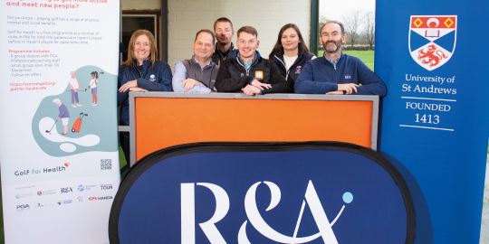 group of people standing with R&A logo