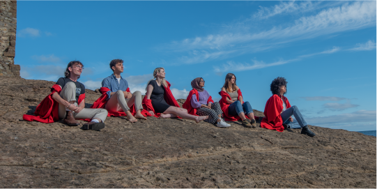 students sitting on a rock