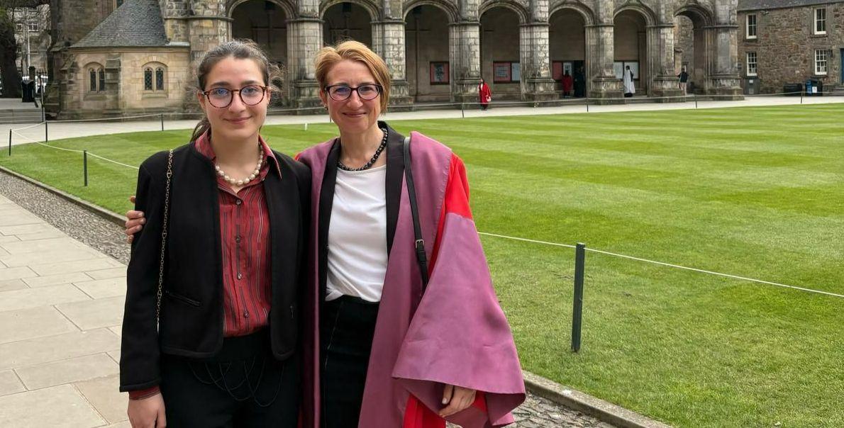 Silvia (right) and her daughter Anita (Left) pose for a photo in St Salvator's Quad. Silvia wears her St Andrews gown. 