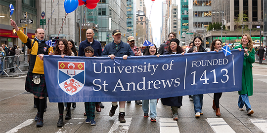 A group of people marching with a banner in New York City A group of people marching with a banner in New York City