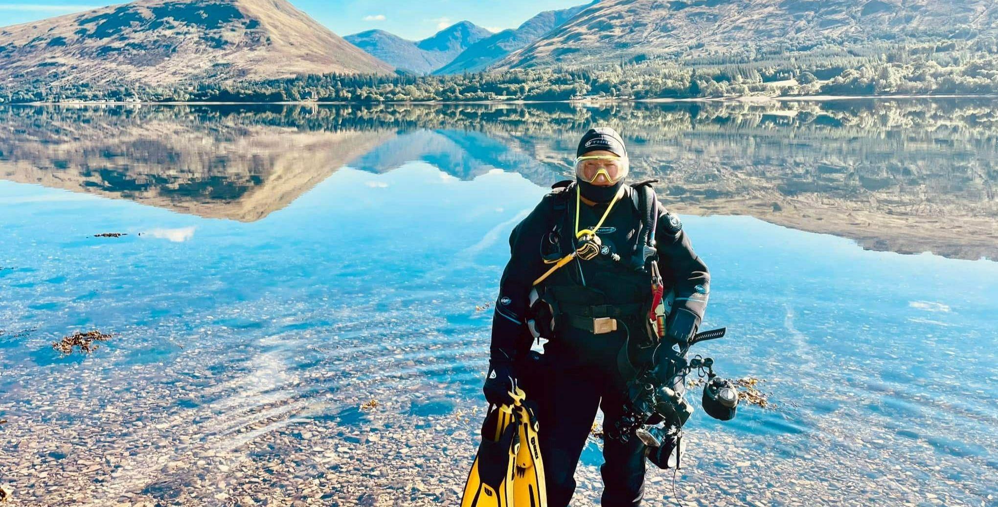 Elaine Whiteford wearing a scuba suit and mask, standing in a loch Elaine Whiteford wearing a scuba suit and mask, standing in a loch