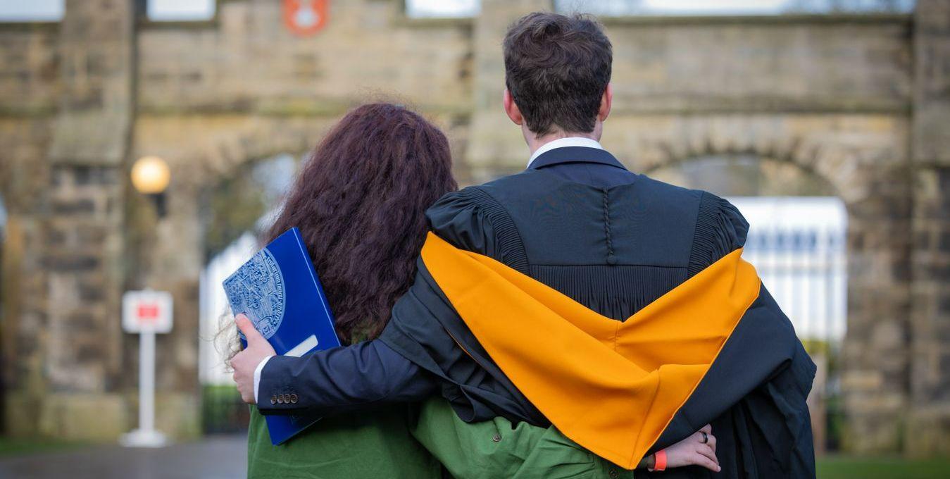 Graduate and parent facing away from the camera