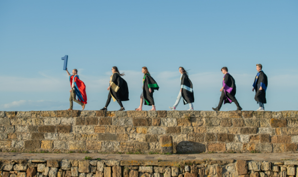 students walking on pier holding number one